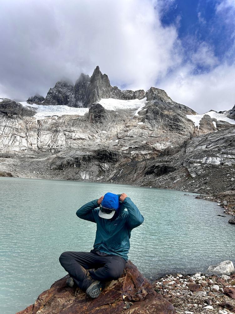 Trekker frente a la laguna glaciar de Torres del Avellano
