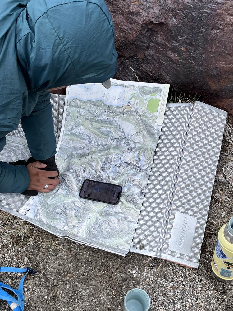 Guía revisando el mapa topográfico de la ruta durante la travesía