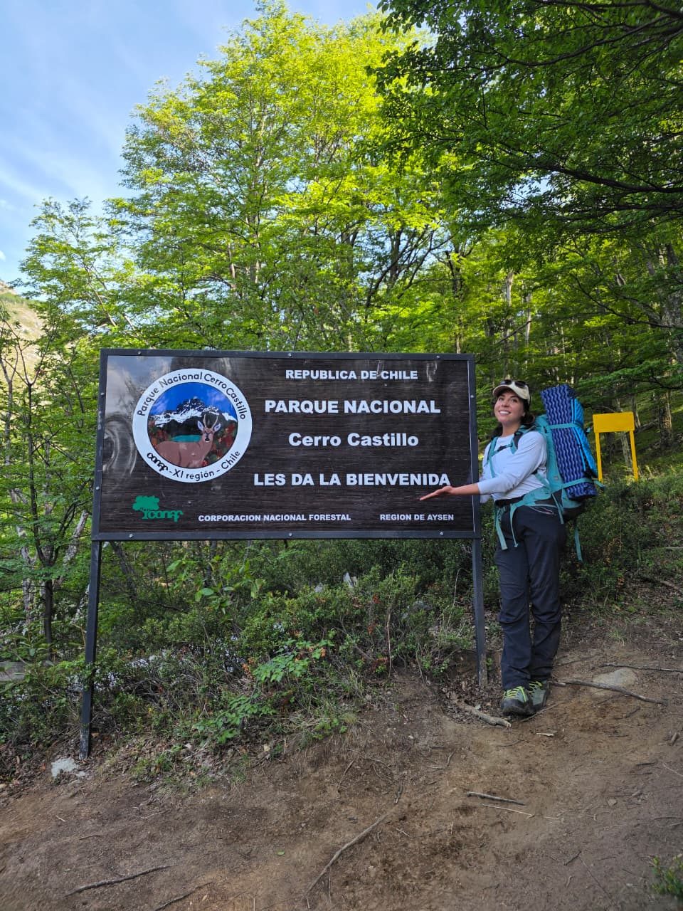 Excursionista en el letrero de bienvenida al Parque Nacional Cerro Castillo
